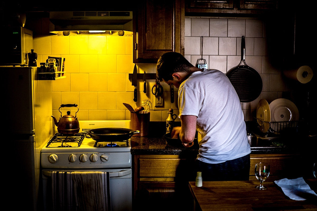 Best stainless steel cookware: A man cooks in a rustic kitchen