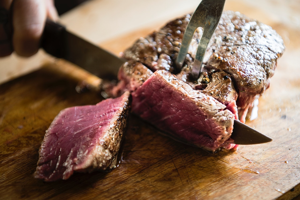Best wood for cutting board: Cooked steak gets sliced on a cutting board