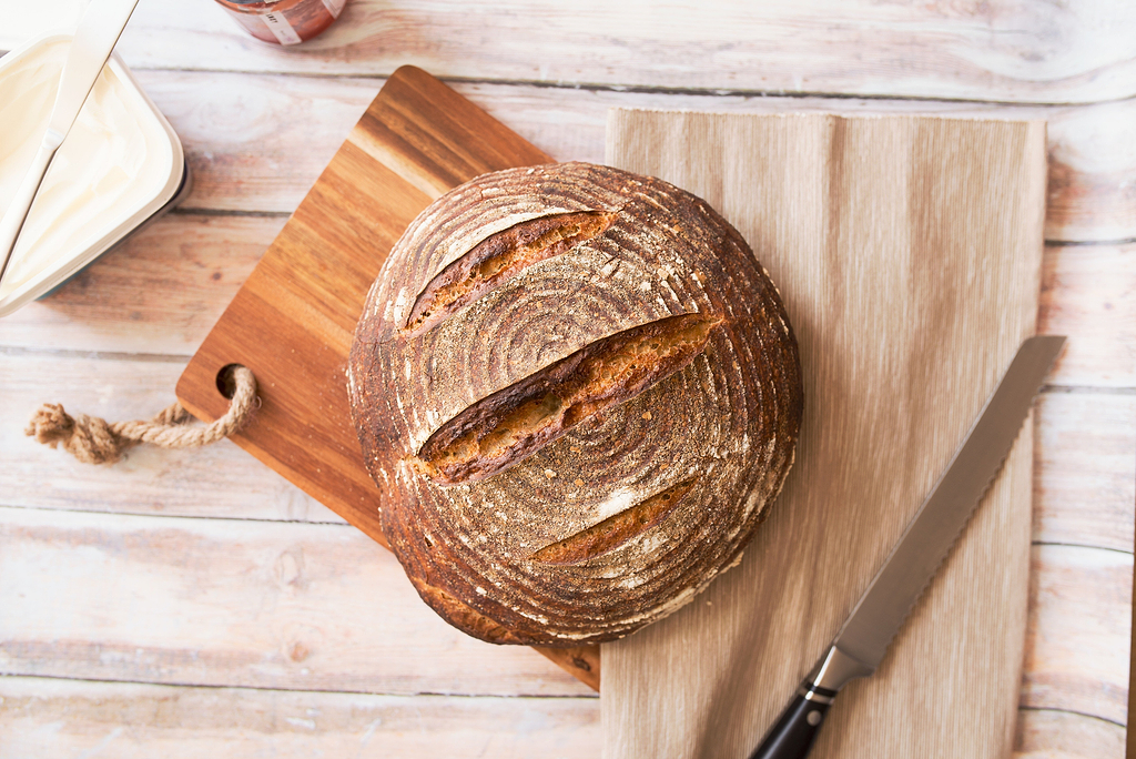 How to sharpen a serrated knife: a loaf of bread on a cutting board next to a bread knife
