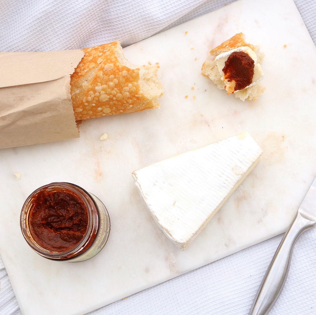 Cutting board material: bread, jam, and cheese on a marble cutting board