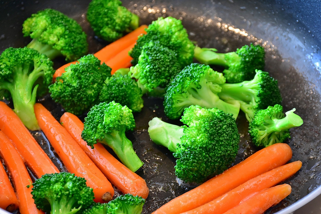 Carrots and broccoli being sautéd