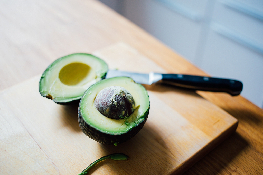 Paring knife: a halved avocado and a knife on a cutting board