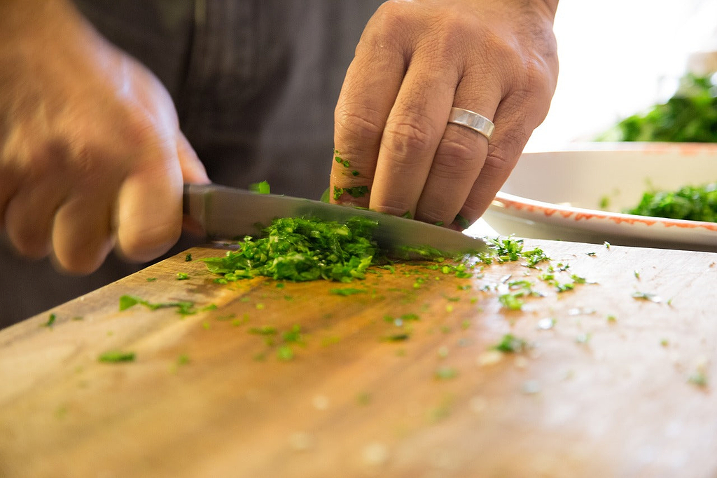 Knife sharpening: A man chops herbs