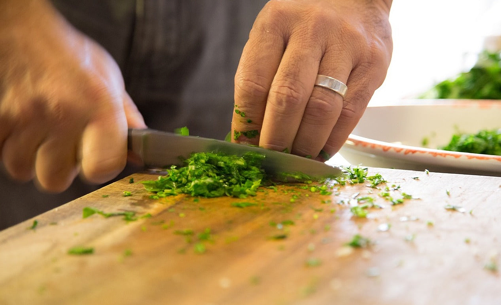 Knife block: A man chops parsley