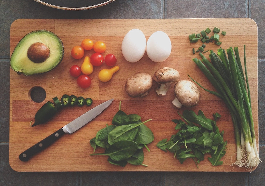 Knife block: a paring knife on a cutting board with a variety of produce