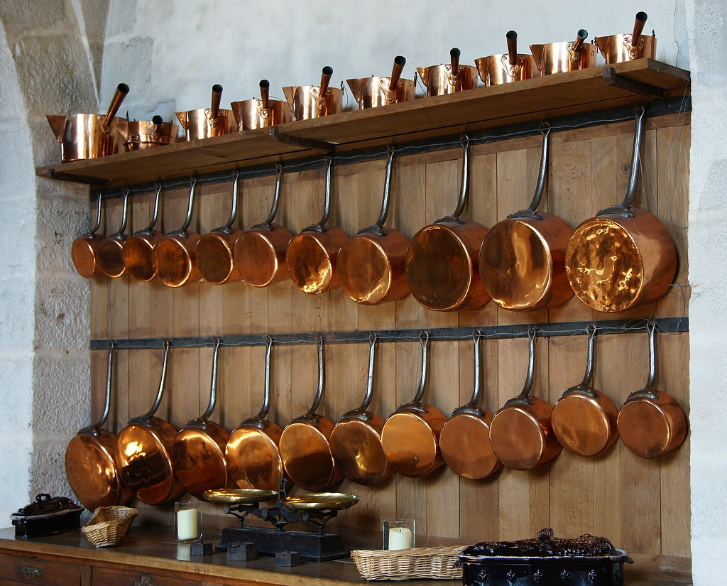 What is a saucepan: copper saucepans hung on a wall