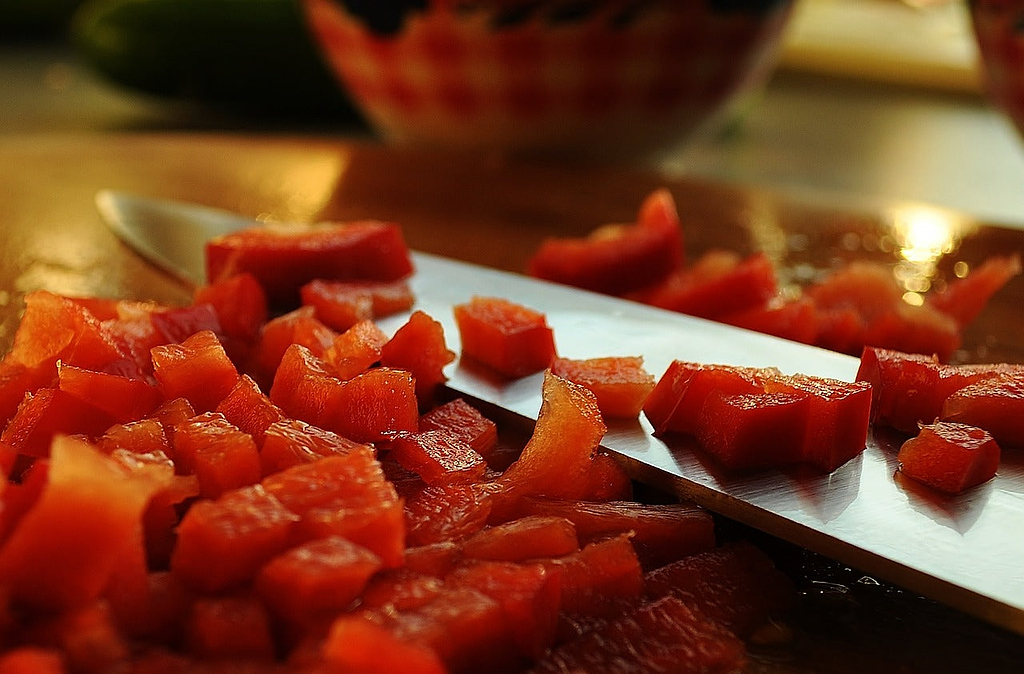 Knife sharpening: a knife surrounded by diced peppers