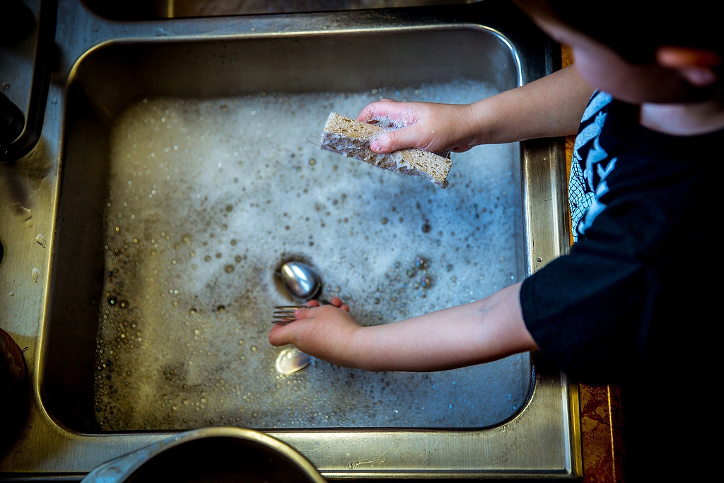 How to cook with stainless steel: Hands wash dishes in the sink