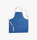 Blue linen bib apron with adjustable neck strap and cream canvas ties