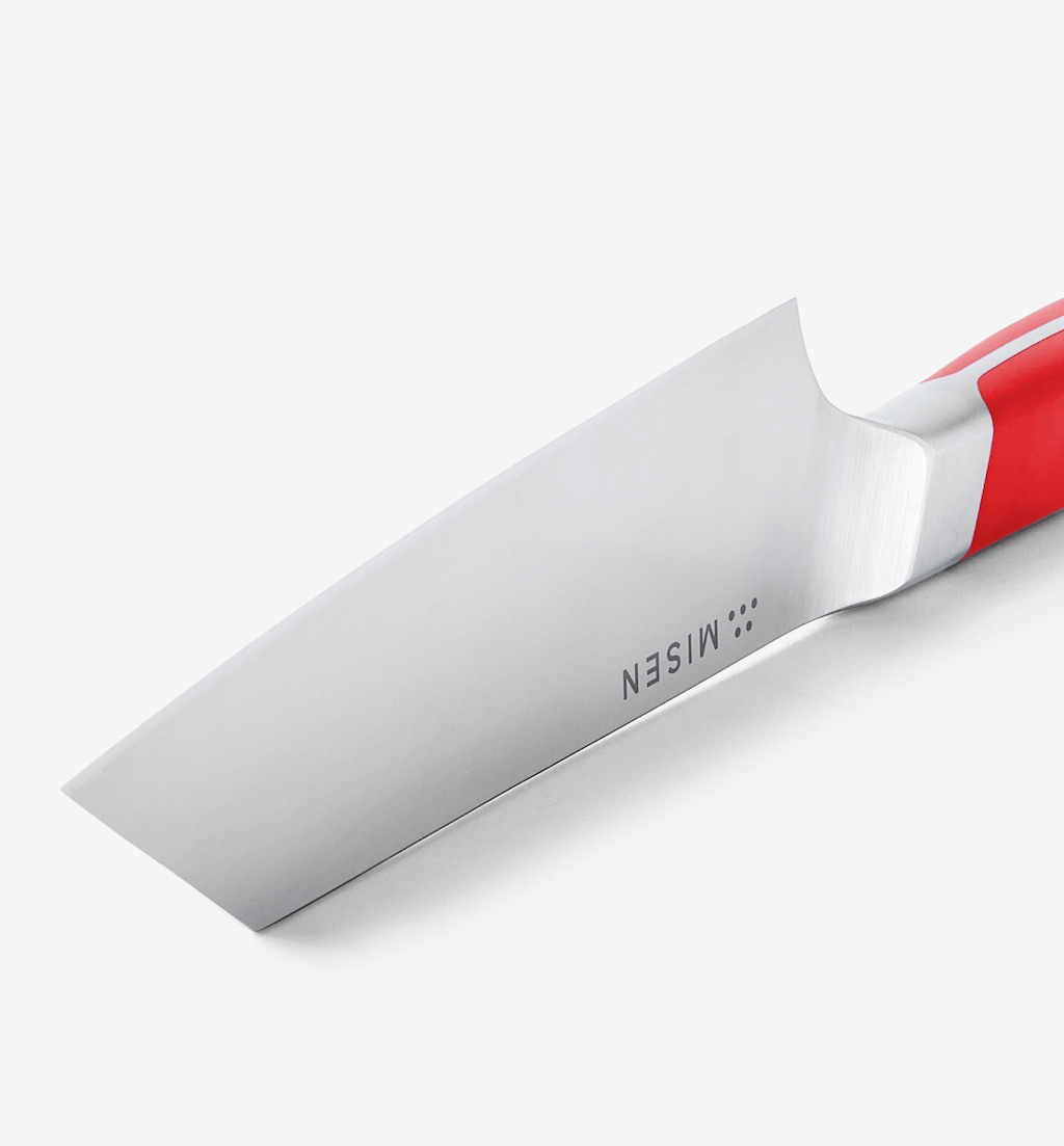 Misen knife blade close-up with red handle showing steel bolster