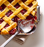 Homemade cherry pie with golden lattice crust in a Misen baking pan, partially served