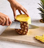 Misen chef's knife cutting pineapple skin on wooden cutting board