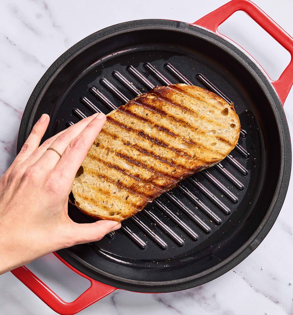 Grilling sourdough bread slice on cast iron grill pan with char marks