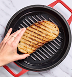 Grilling sourdough bread slice on cast iron grill pan with char marks