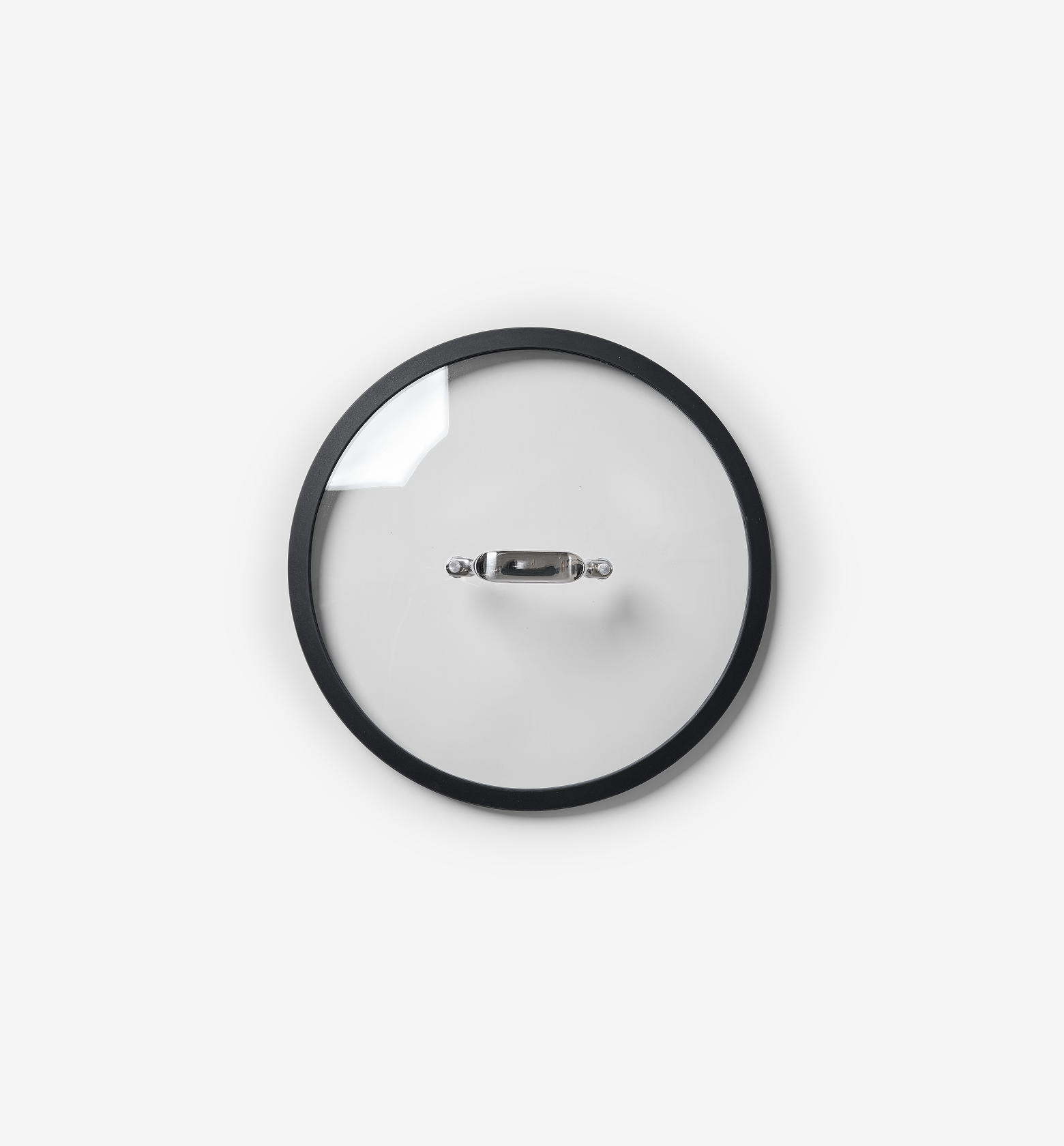 Glass pot lid with black rim and stainless steel handle, top-down view