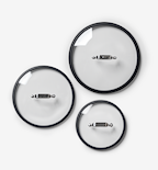 Set of three glass cookware lids with black rims and stainless steel handles in small, medium, and large sizes