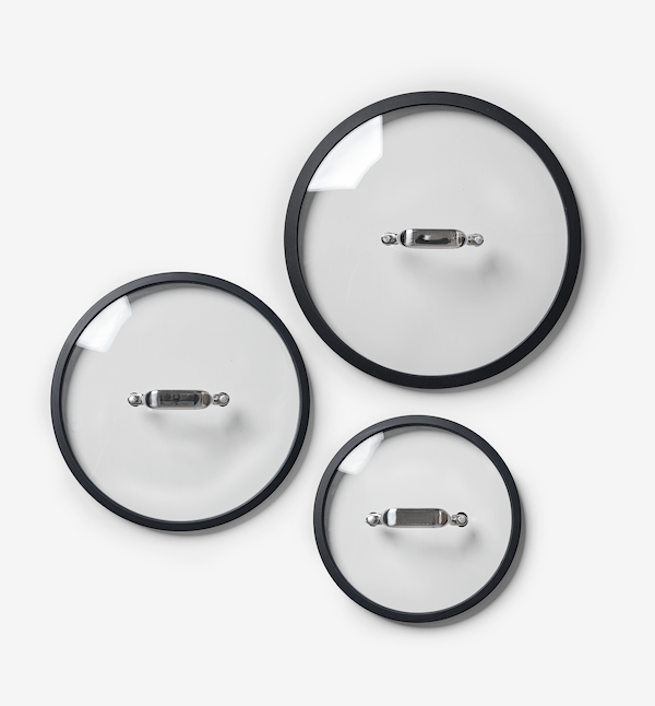 Set of three glass cookware lids with black rims and stainless steel handles in small, medium, and large sizes
