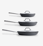 Set of three hard-anodized nonstick frying pans with glass lids and stainless steel handles in graduated sizes