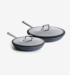 Dark gray nonstick frying pans set with glass lids and stainless steel handles, two sizes