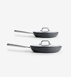 Two dark gray nonstick frying pans with glass lids and stainless steel handles