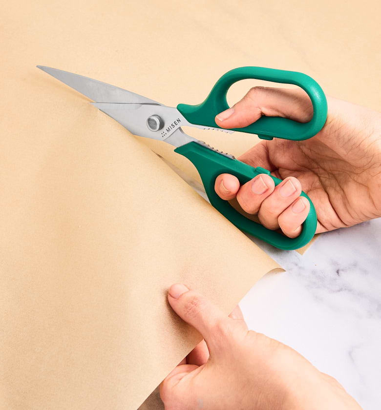 Misen kitchen scissors cutting kraft paper with teal handles