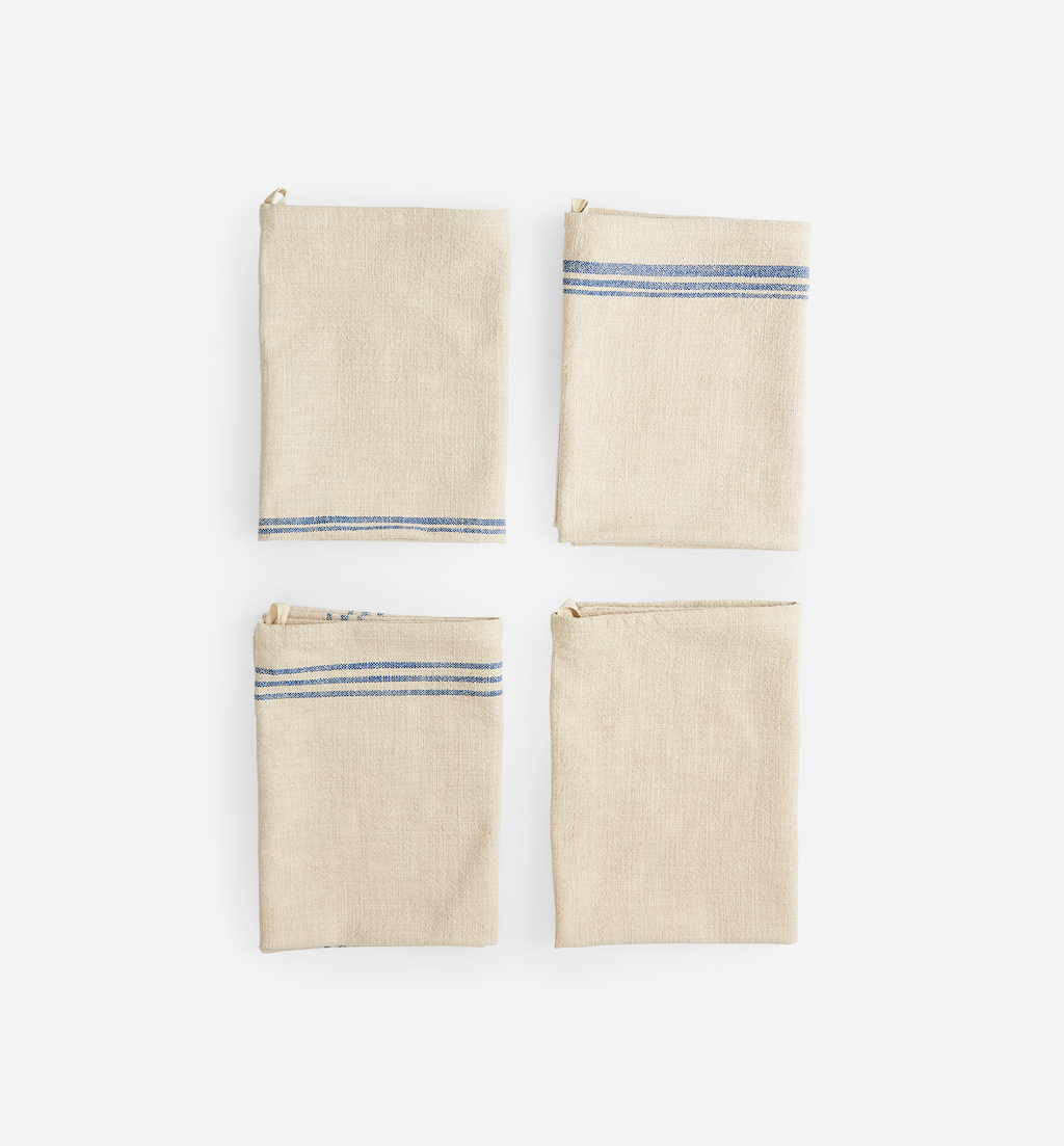 Set of four folded linen kitchen towels with blue stripe detail