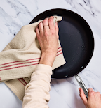 Drying a nonstick frying pan with a linen dish towel