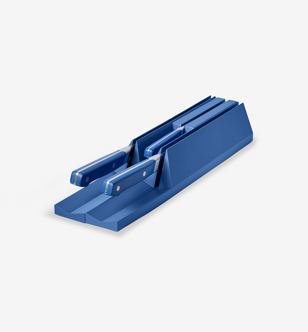 Blue knife drawer organizer block holding matching blue-handled kitchen knives