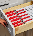 Kitchen drawer organizer with red-handled steak knives stored safely in divided slots