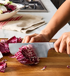 Misen chef's knife slicing radicchio on wooden cutting board