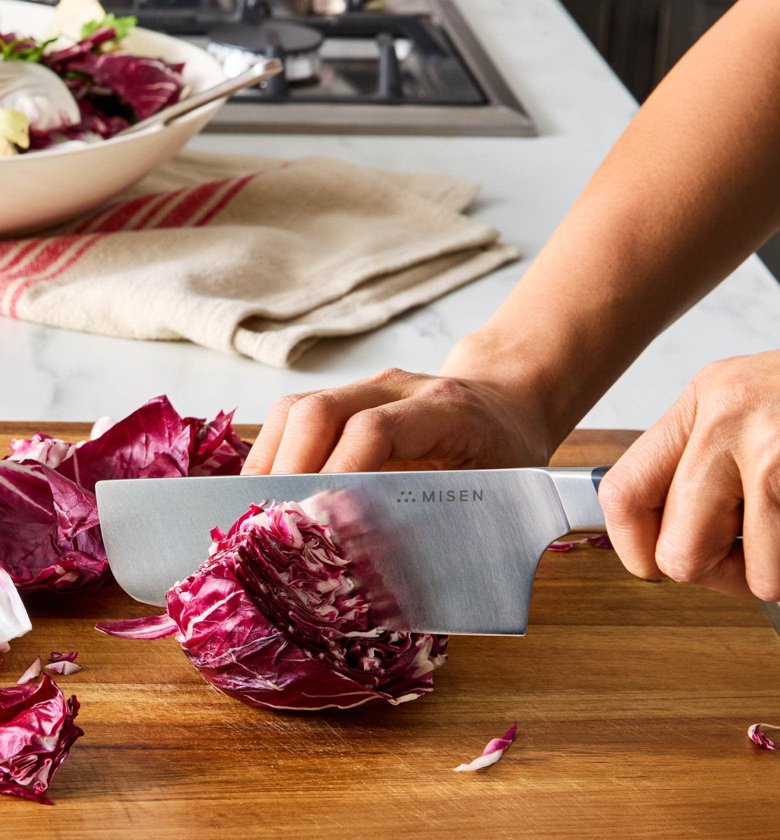 Misen chef's knife slicing radicchio on wooden cutting board