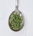 One tablespoon of fresh thyme leaves on stainless steel measuring spoon