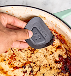 Misen pan scraper cleaning burnt food residue from enameled cast iron skillet
