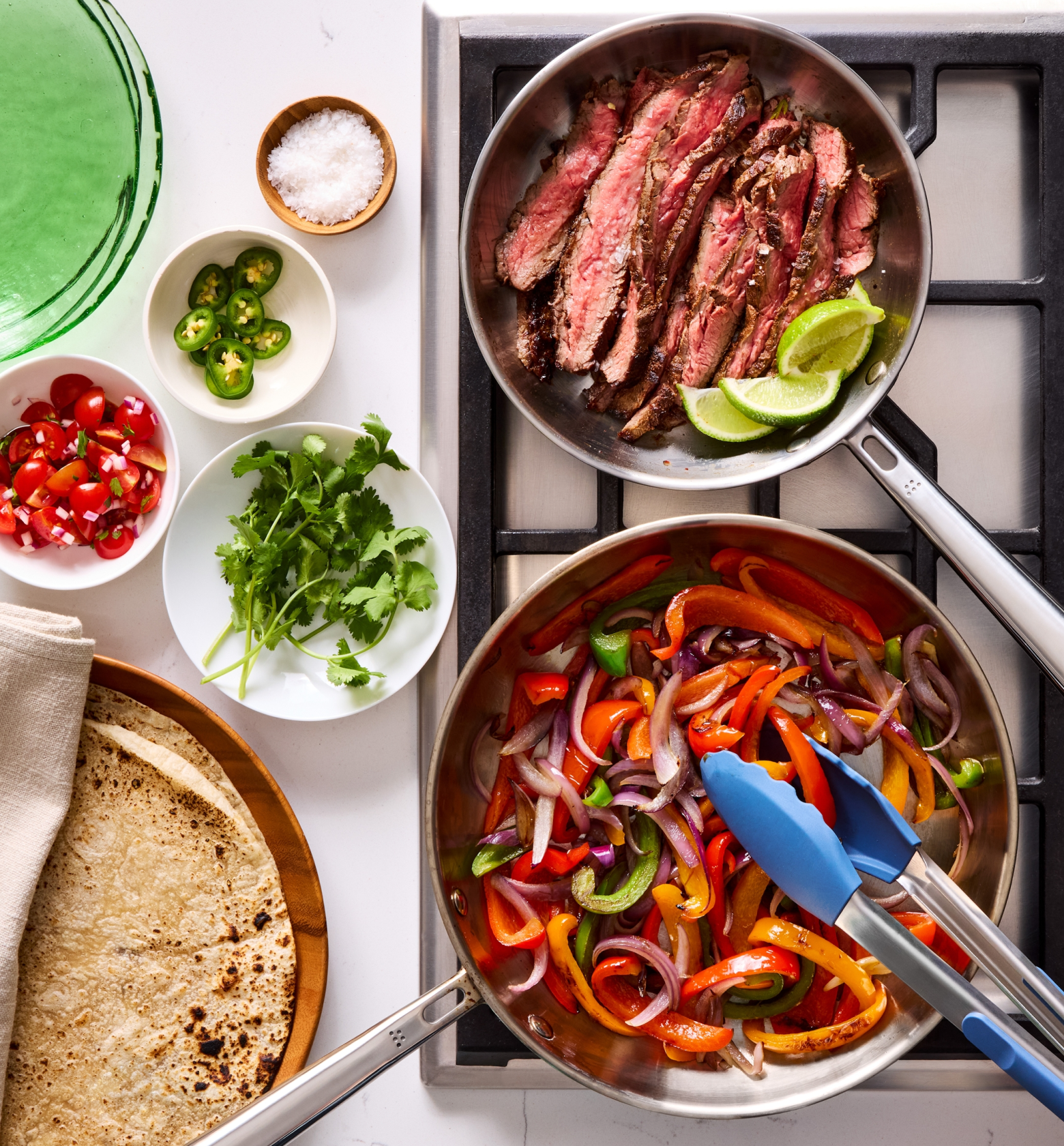 Steak fajitas with sautéed bell peppers, onions, warm tortillas, and fresh toppings