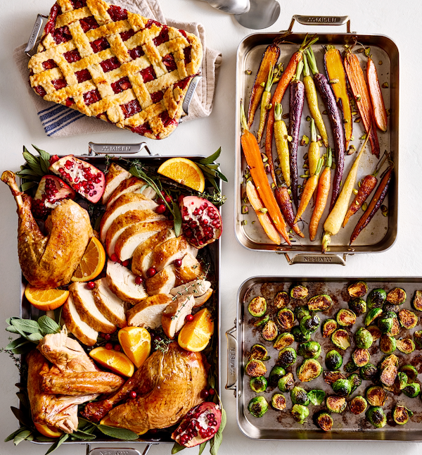Thanksgiving feast spread with roasted turkey, rainbow carrots, Brussels sprouts, and cranberry lattice pie in Misen stainless steel pans