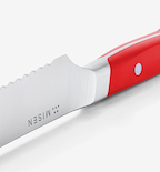 Misen steak knife with serrated blade and red handle close-up