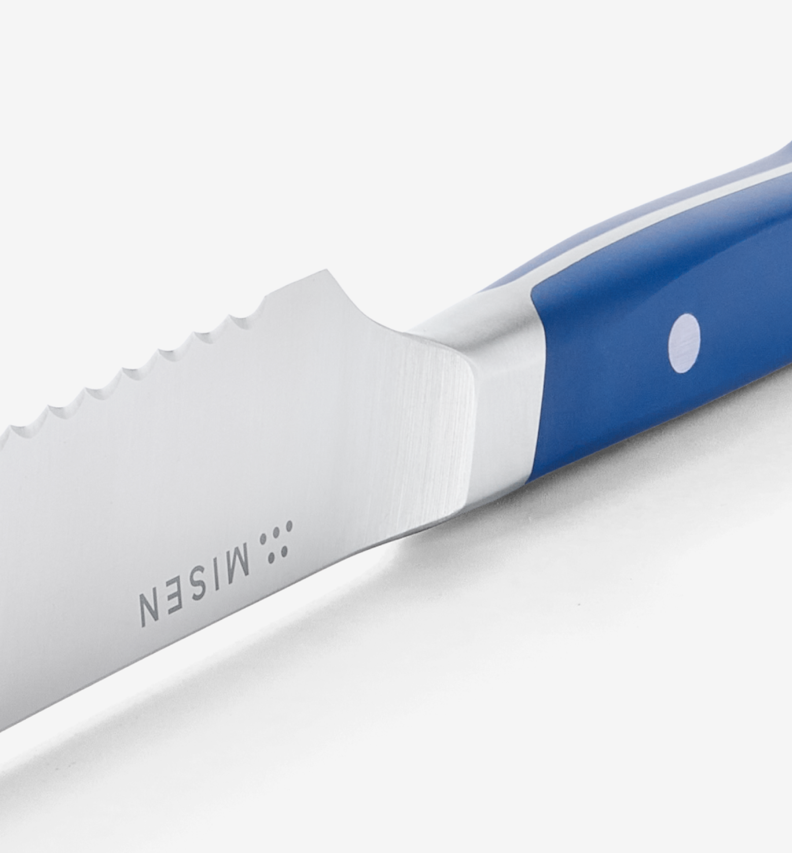 Misen steak knife with serrated blade and blue handle close-up