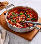 Misen stainless steel braiser pan with shrimp tomato bean stew garnished with fresh herbs