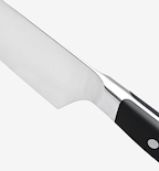 Chef's knife close-up showing stainless steel blade, bolster, and black handle with rivets