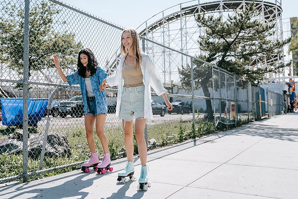 two women roller skating down the street