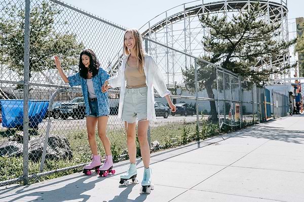 two women roller skating down the street