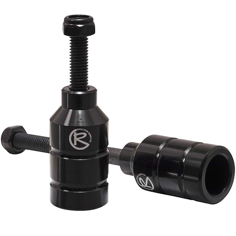Two black Revolution Aluminium Stunt Scooter Pegs, designed from CNC milled aluminum, feature a cylindrical shape with a bolt on top for easy installation and the "R" logo on the side. Built to enhance your scooter's performance and durability, they offer precision engineering for stunts.