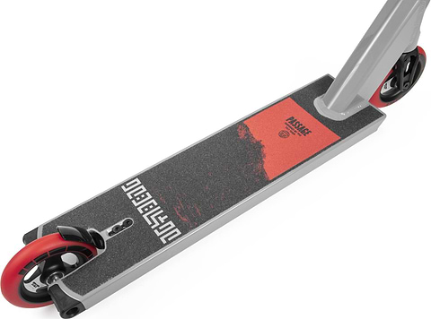 A close-up of the Tilt Passage Build Pro Complete Stunt Scooter - Red showcases its stunning red and black graphics on the deck. The front and back feature matching red wheels, accentuated by sleek metal details around the durable 6061 aluminium frame. The scooter deck includes a textured grip surface, a robust T-bar, and prominently displays the Tilt brand logo in bold letters.