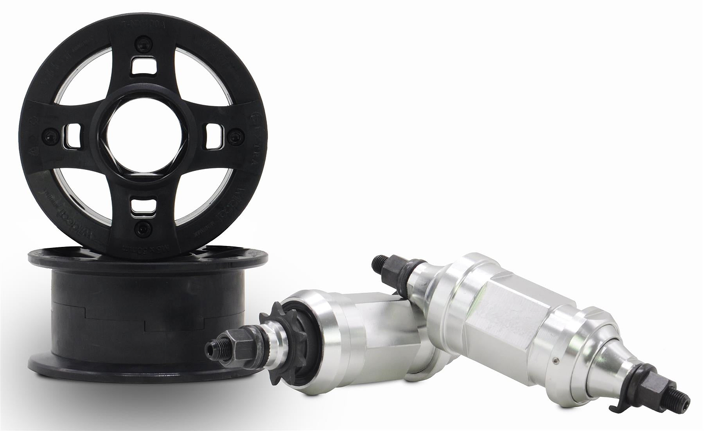 Two black CNC aluminum wheel rims stand and lie flat next to two metallic cylindrical, threaded components—parts from the Wildcat OG 3A Mini BMX Bike - Galaxy Gum by Wildcat—against a white background.