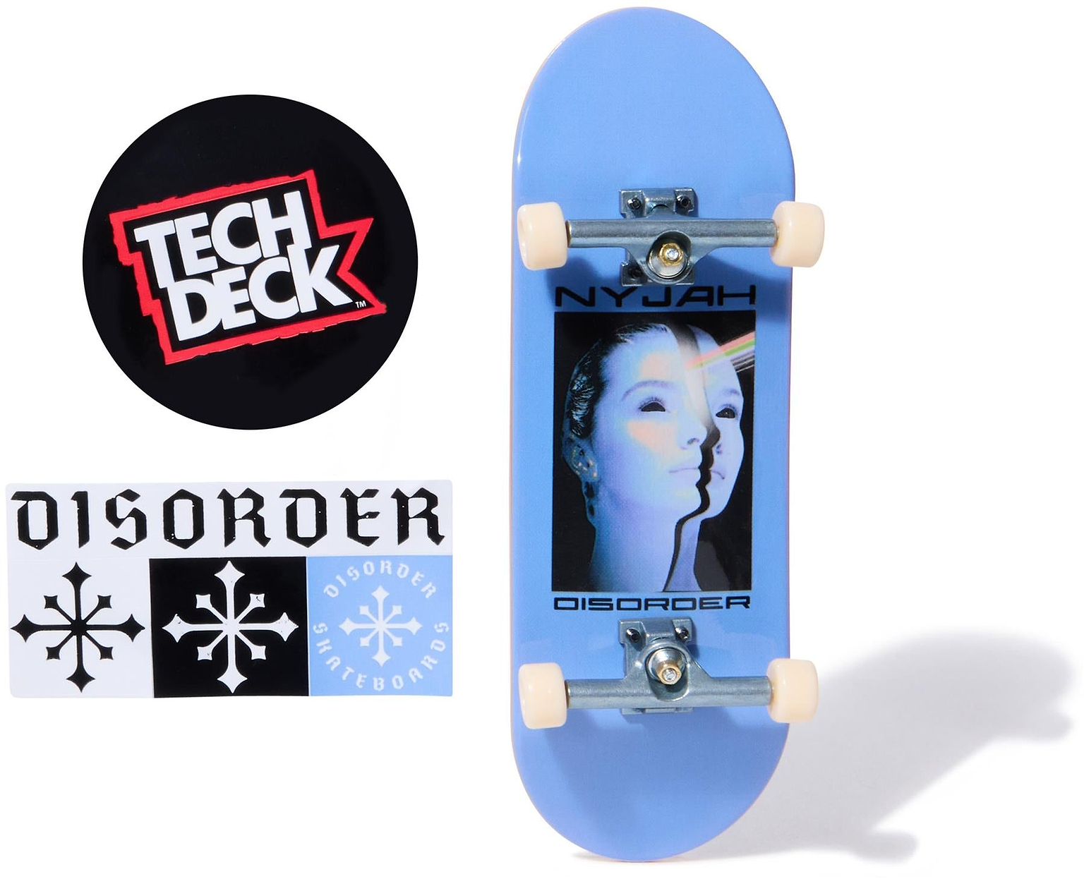 The Tech Deck 96mm M54 Fingerboard - Disorder features a blue board with a woman's face and "NYJAH DISORDER" text, plus two stickers—a round "TECH DECK" logo and a snowflake "DISORDER" sticker—ideal for collectors.