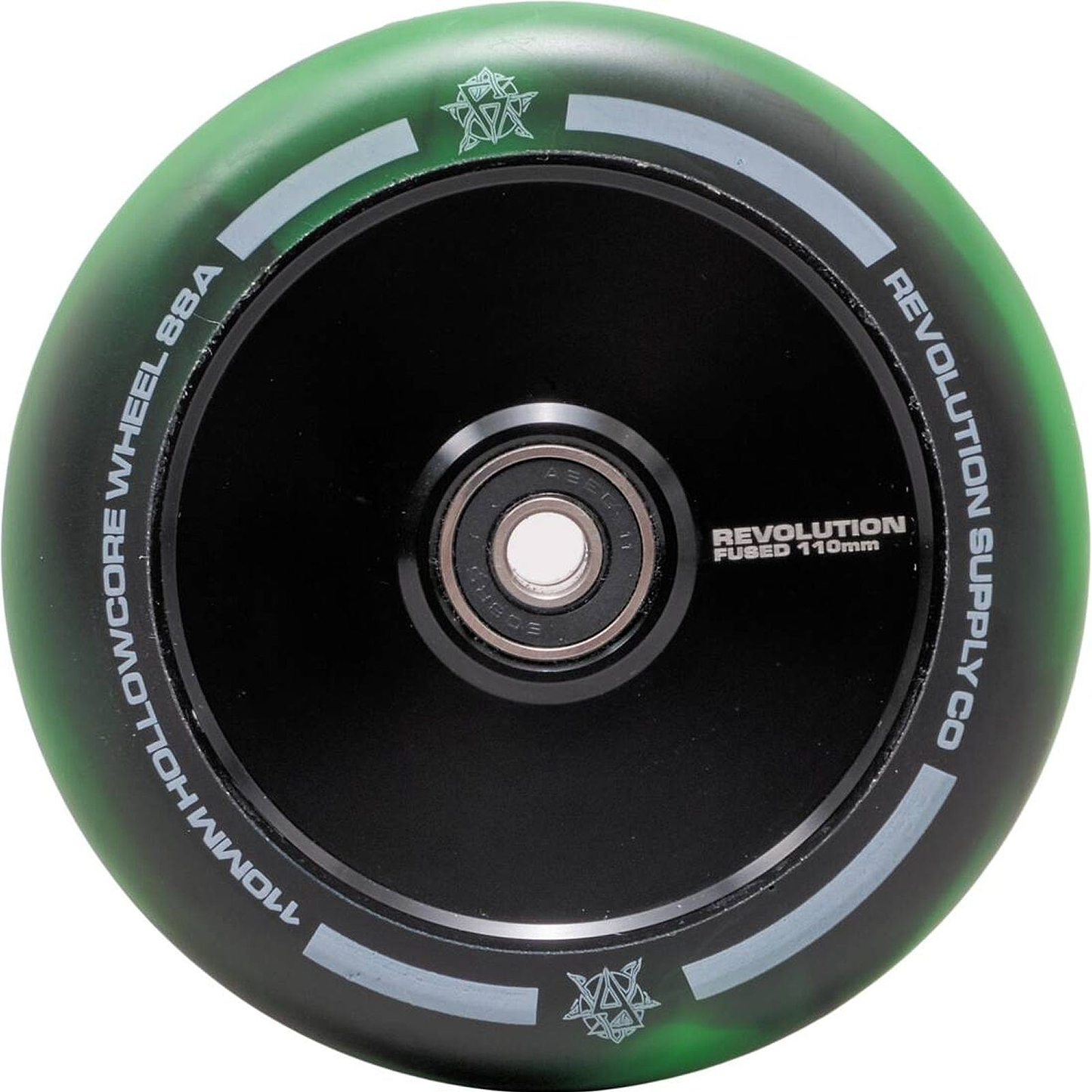A close-up of a black and green Revolution Fused Core 110mm Stunt Scooter Wheel by Revolution highlights their Fused Wheel Technology. The wheel is labeled "110mm Hollowcore Wheel 88A," with "Revolution Fused 110mm" also visible. The design is enhanced with small star-like symbols on the rim, adding intricate detail to the scooter wheels.