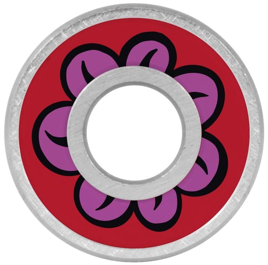 The round metal object has a red center with a five-petaled purple flower outlined in black, each petal containing a black curve. The hollow circle resembles Bronson Speed Co. Fabiana Delfino Pro G3 skateboard bearings.