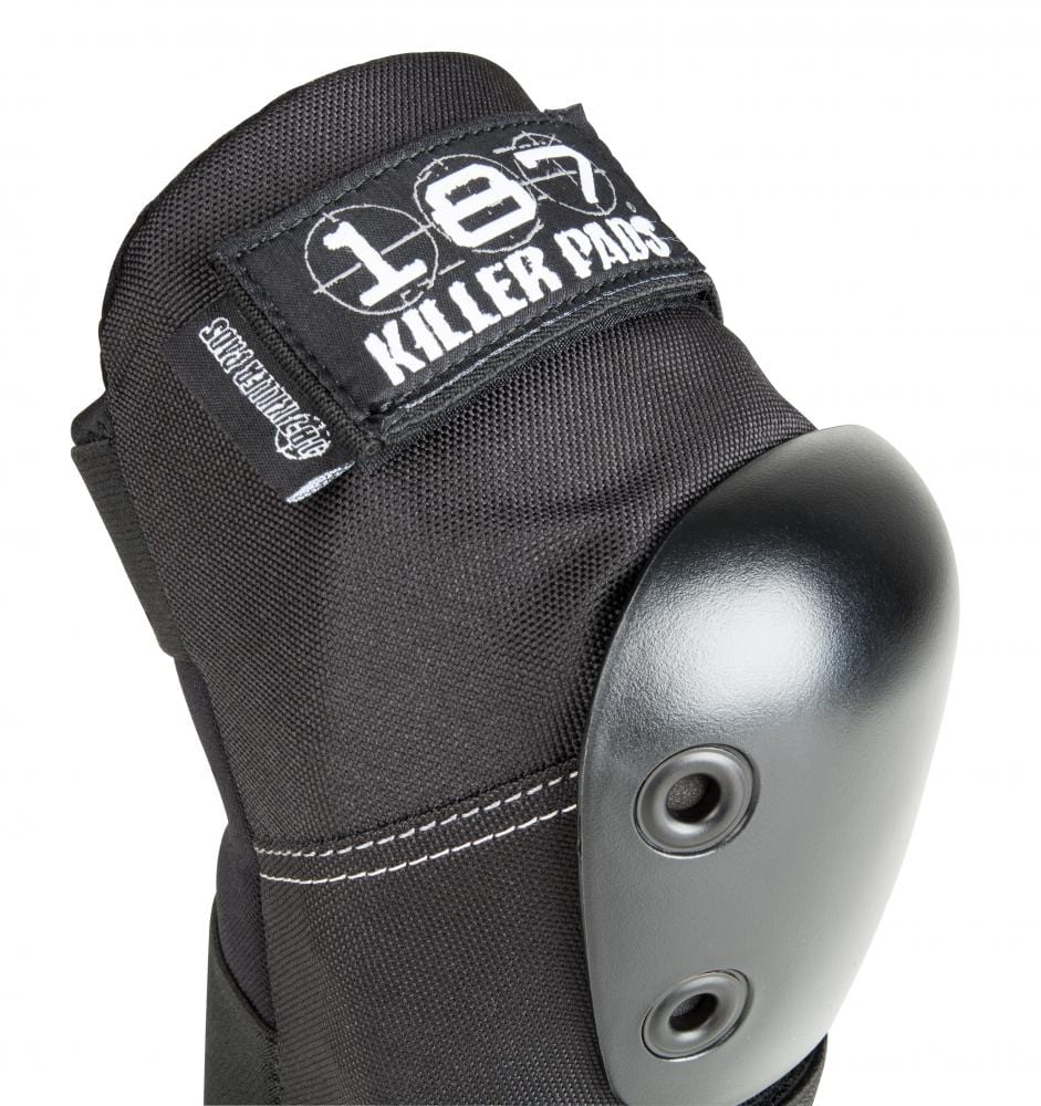 Close-up of a black elbow pad featuring a hard shell, two rivets, and a fabric label reading "187 Killer Pads." The white stitching and rugged design indicate it's for impact protection. Perfect for anyone in need of reliable gear like the 187 Killer Pro Elbow Skate Protection Pads - Black.