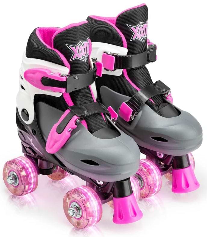 The Xootz LED Adjustable Quad Roller Skates - Pink by Xootz feature a gray, black, and white design with pink accents and wheels. Adjustable straps and a supportive cuff offer comfort and control—perfect for beginner kids.