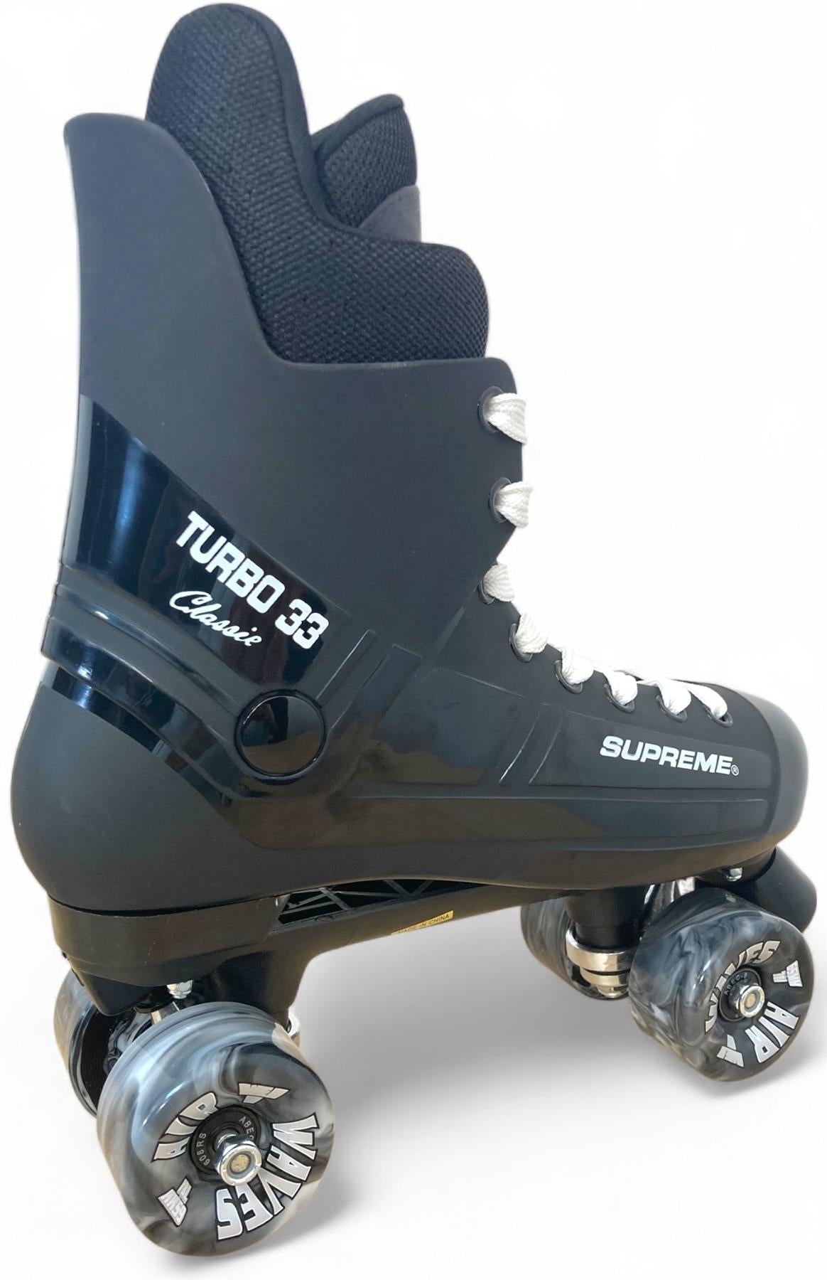 The Supreme Turbo 33 Nylon Quad Roller Skates feature a black durable nylon boot with padded ankle support, white laces, and four black swirl wheels. Styled after the Bauer Turbo 99, these classic skates combine comfort and performance.